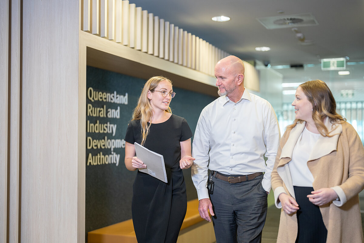 Two female and one male QRIDA staff members walking in foyer of QRIDA office