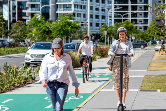 Brisbane city street with people walking, riding a bike and scooter