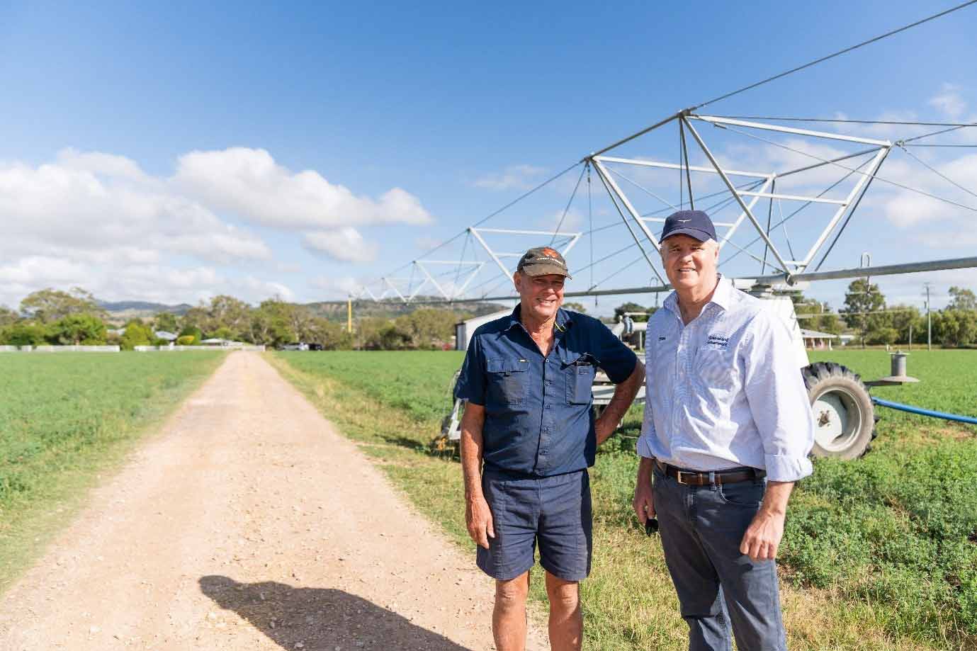 Steve Neuendorf with QRIDA former CEO, Cameron MacMillan standing in front of a irrigator