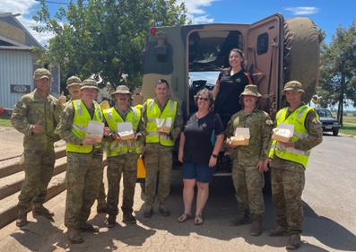 Hooper's Grantham Store owner Tanya Hooper with defence personnel during flood recovery.