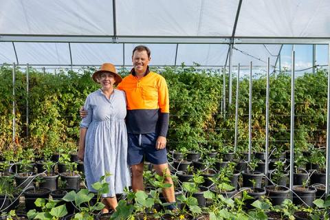 Jessica and Luke Volker standing in their greenhouse